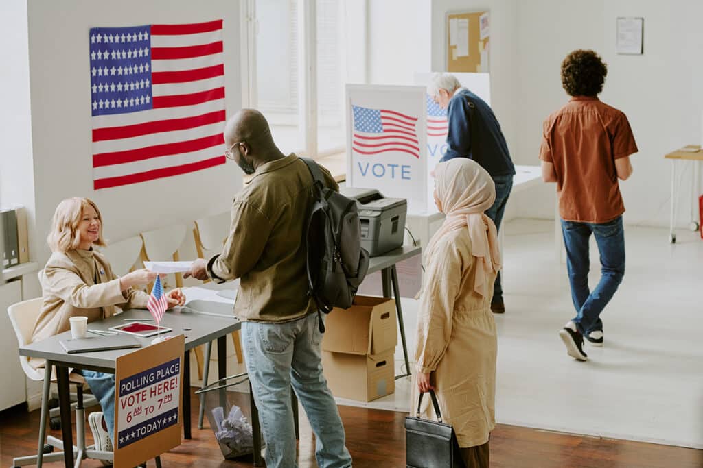 voting location with two people standing in line to collect their ballot